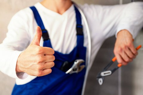 Installateur sympathisch lachend bei der Arbeit 